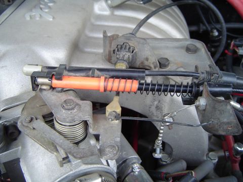 1989 Ford Bronco - This image shows a close-up view of a vehicle's throttle cable assembly, focusing on the linkage and springs.