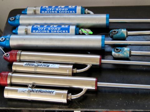 1996 Ford Bronco - A collection of King Off-Road Racing Shocks and RaceRunner shocks are laid out on a dark surface.