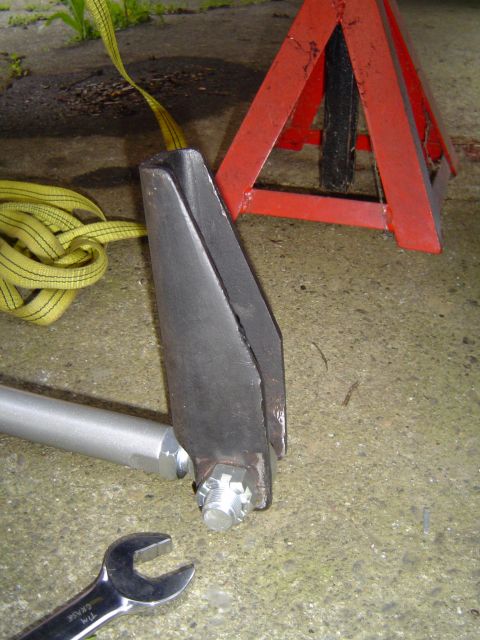 1978 Ford Bronco - A vehicle part is shown with a strap and jack stand, suggesting maintenance or repair work.