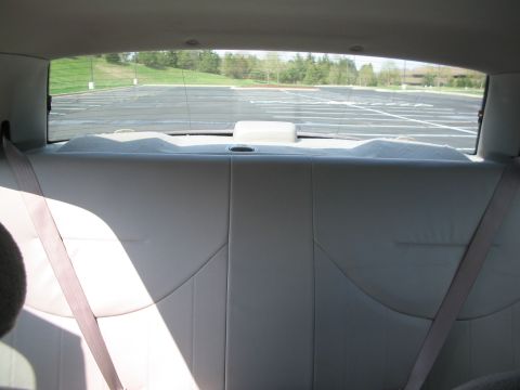 2001 Ford Crown Victoria - View of the rear interior of a vehicle, including the back seat and seatbelts, looking out the rear window.
