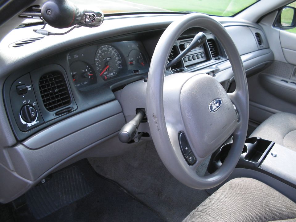 Interior dashboard of a 2001 Ford Crown Victoria, showing steering wheel, gauges, and center console