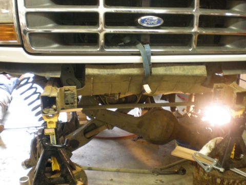 1993 Ford Bronco - The front end of a 1993 Ford Bronco is shown, lifted on jack stands for maintenance.