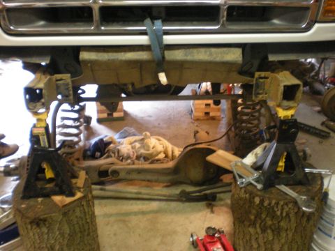 1993 Ford Bronco - Front suspension of a 1993 Ford Bronco being worked on, lifted by jack stands.