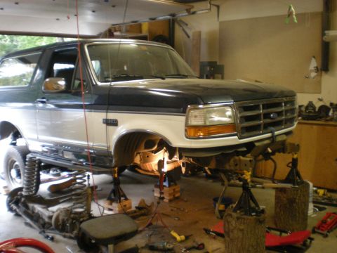 1993 Ford Bronco - This Ford Bronco is undergoing front-end repair work in a garage setting.