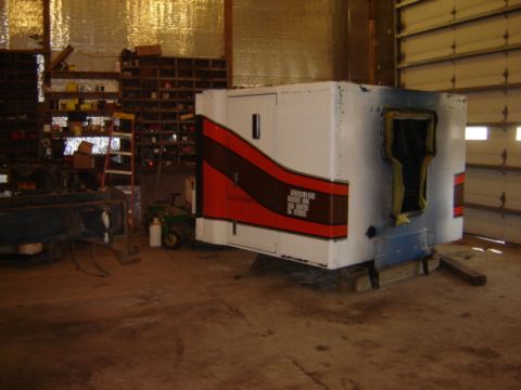 1992 Ford Bronco - An RV camper shell is seen in a workshop, resting on wooden blocks.