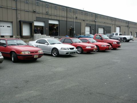 2001 Mercury Grand Marquis - A silver coupe is parked in front of a warehouse, alongside several other vehicles.