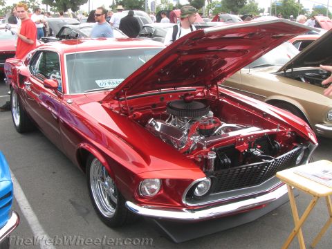 1968 Ford Mustang - A shiny red 1969 Ford Mustang is displayed with its hood open, revealing the engine bay.