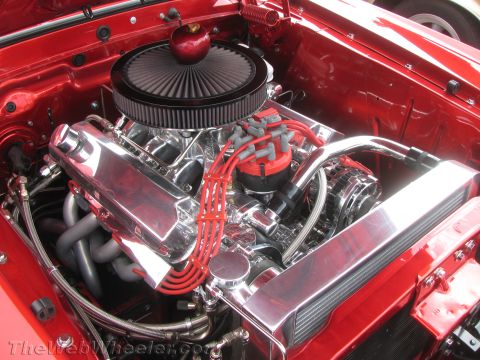 1968 Ford Mustang - Close-up of a custom V8 engine bay, chrome components and a unique apple ornament.