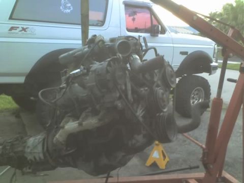 1995 Ford Bronco - Engine being worked on, with a Ford Bronco visible in the background.