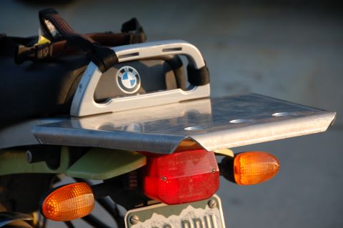 1998 BMW R1100GS ABS - Close-up of a motorcycle's rear rack, the BMW emblem and a metal plate for luggage.
