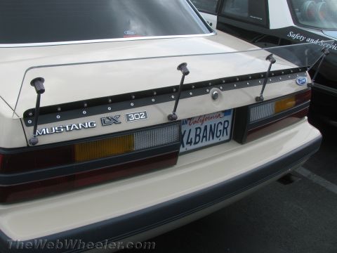 1968 Ford Mustang - Rear view of a tan Mustang LX 302 a clear spoiler and California license plate.