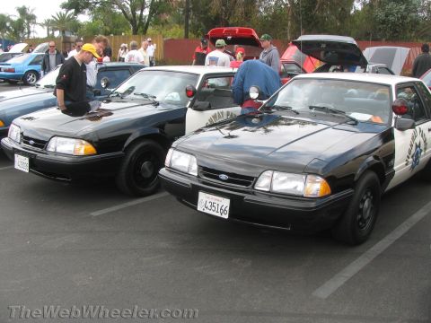 1968 Ford Mustang - Two police cars, likely Ford Mustangs, are parked in a lot. One car has "HIGHWAY PATROL" visible on its side.