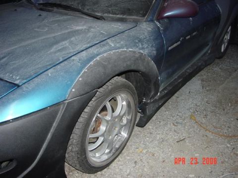 1993 Ford Probe - Close-up of a car's front fender and wheel well with aftermarket fender flares.