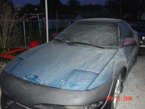 1993 Ford Probe - A dusty blue coupe sits outside with a red gas can nearby.