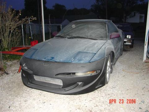 1993 Ford Probe - A blue car with a black aftermarket body kit is parked outdoors. The vehicle is viewed from a three-quarter front angle, and a date stamp i…