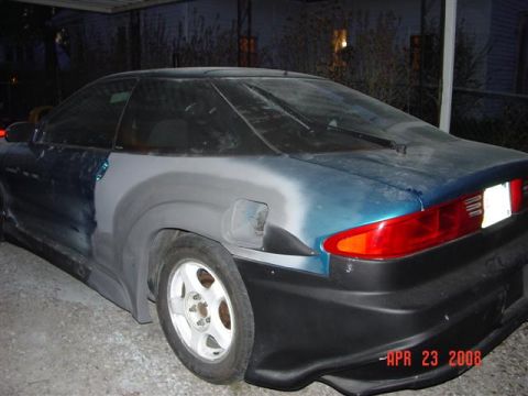 1993 Ford Probe - A car's rear quarter panel shows primer and body filler, indicating ongoing bodywork.