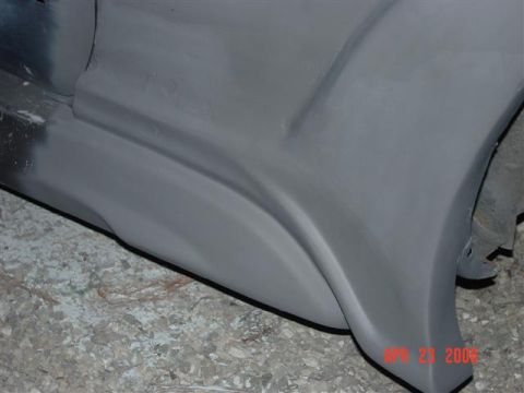 1993 Ford Probe - A close-up view of a car's body panel, prepared with primer for further work.