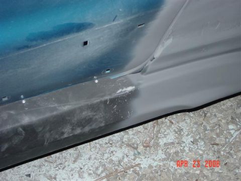 1993 Ford Probe - Close-up of a car's side panel undergoing bodywork, with visible primer and trim details.