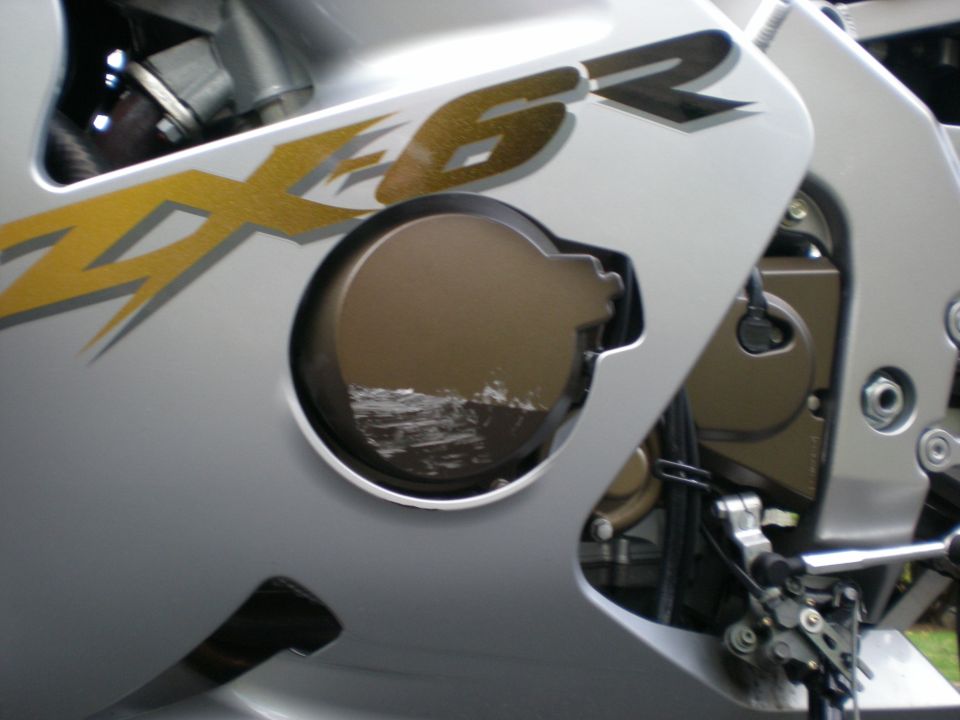 Silver ZX-6R sportbike fairing with cutout exposing gold engine clutch cover