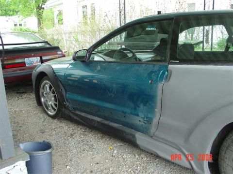 1993 Ford Probe - A Ford Probe is shown with bodywork in progress, parked next to a red Ford Mustang.