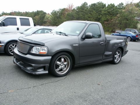 2001 Mercury Grand Marquis - A gray Ford F-150 Lightning pickup truck is parked in a lot with other vehicles.
