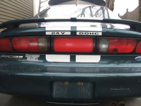 1997 Ford Probe - The rear of a green car displays racing stripes and various badges, including 'PROBE' and '24V DOHC'.