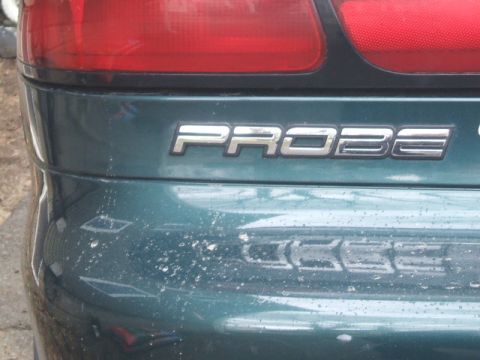 1997 Ford Probe - Close-up of the 'PROBE' badge on the rear of a dark green vehicle.
