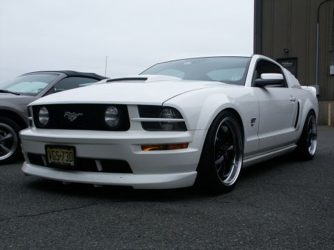 2001 Mercury Grand Marquis - White Ford Mustang GT with custom hood scoop and wheels, parked next to another car.