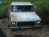 1979 Ford Bronco - This Ford pickup truck is stuck deep in the mud, with only its front end visible.