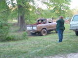 1979 Ford Bronco - A brown pickup truck appears to be stuck in the mud, with a person observing the situation.