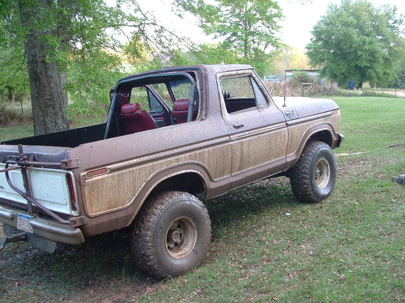 1979 Ford Bronco, brown and white, 3/4 front view, muddy exterior, red interior