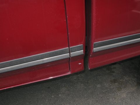 1991 Ford F-150 - Close-up of the side panel and bed seam on a red 1991 Ford F-150 pickup truck.
