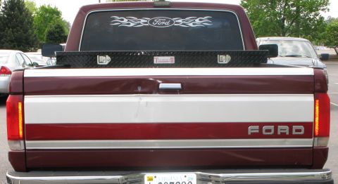 1991 Ford F-150 - This Ford pickup truck features a two-tone paint scheme with red and white stripes on the tailgate.