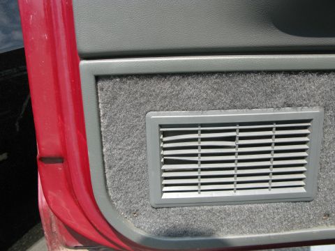 1991 Ford F-150 - Close-up of a car's interior door panel, showing a vent and red exterior paint. "SUPERMOTORS.NET" watermark present.