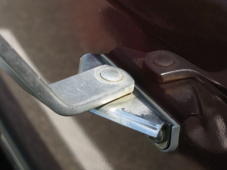 Close-up of a vehicle's door handle mechanism and hinge