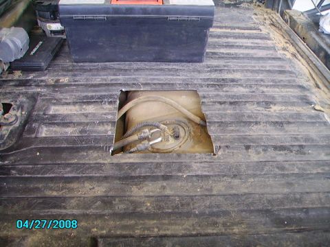 1990 Ford Bronco - Access hole cut into truck bed to reach the fuel tank and associated lines.