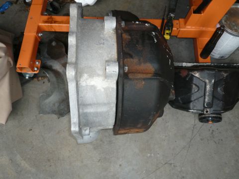 1974 Land Rover Land Rover - Automotive transmission and differential parts shown on a concrete floor with an engine stand in the background.