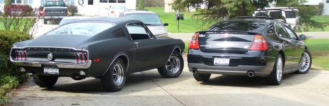 2002 Chrysler 300M - A black 2002 Chrysler 300M is parked next to a classic Ford Mustang in a driveway.