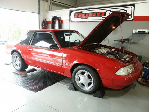 2001 Mercury Grand Marquis - Red Ford Mustang coupe on a dynamometer, hood open, showing the engine bay.