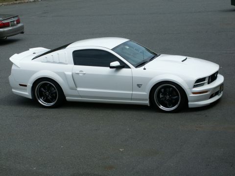 2001 Mercury Grand Marquis - White Ford Mustang GT parked on asphalt, with another vehicle in the background.