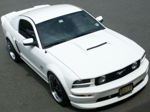 2001 Mercury Grand Marquis - A white Ford Mustang is parked on asphalt, viewed from a high angle.