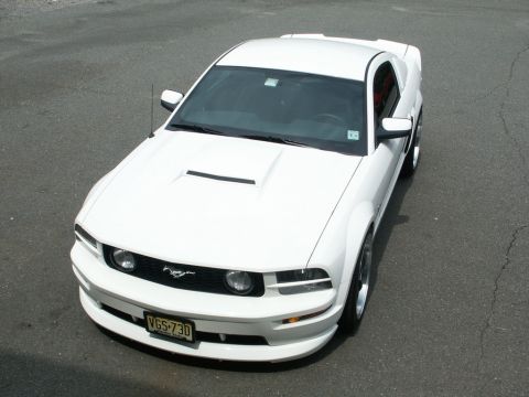2001 Mercury Grand Marquis - A white Ford Mustang is parked on asphalt, viewed from a high angle.