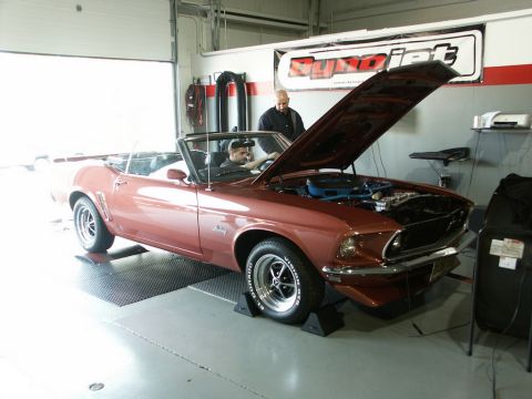 2001 Mercury Grand Marquis - A red 1969 convertible Mustang is positioned on a dynamometer with its hood open, ready for testing.