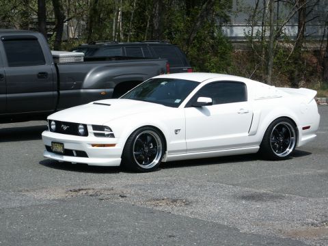 2001 Mercury Grand Marquis - White Ford Mustang GT parked next to a dark pickup truck.