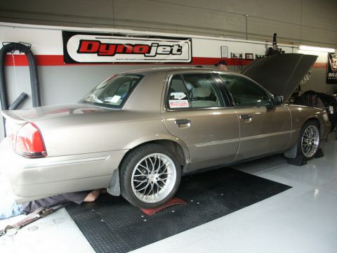 2001 Mercury Grand Marquis - A tan 2001 Mercury Grand Marquis is positioned on a dynamometer with its hood open, under a Dynojet banner.