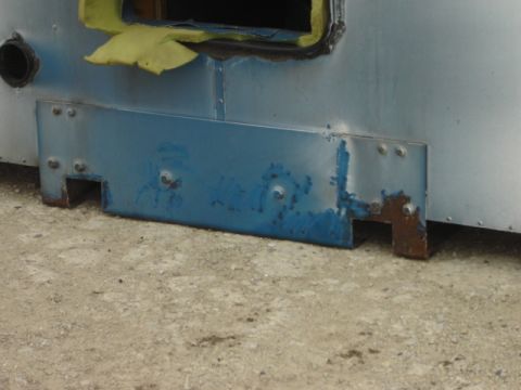 1992 Ford Bronco - Close-up view of a blue metal bracket attached to the exterior of a silver vehicle.