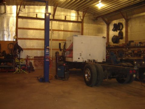 1992 Ford Bronco - Garage scene with a truck chassis and a box body, plus another vehicle in the background.