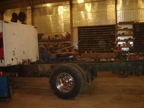 1992 Ford Bronco - The bare frame of a truck is visible, with a white box body mounted on the front and dual rear wheels.