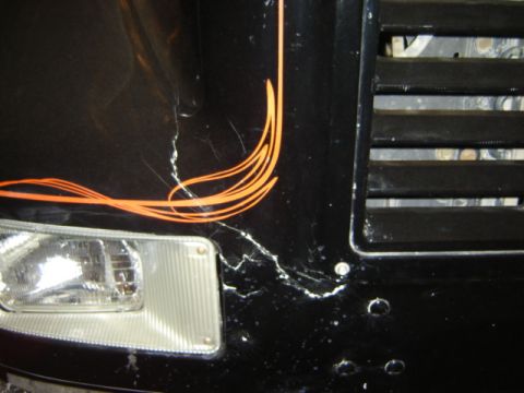 1992 Ford Bronco - Close-up of a vehicle's front corner showing damage and custom pinstriping.