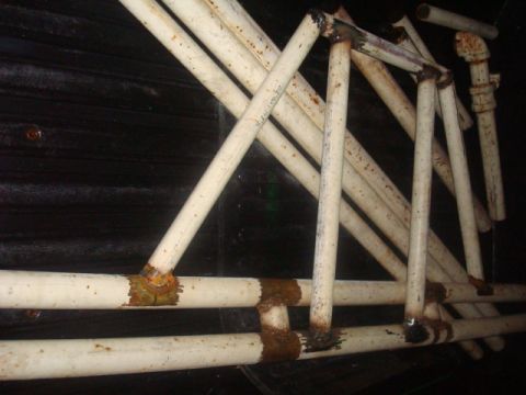 1995 Ford Explorer - The photo shows a section of rusted white pipes, possibly part of a frame or support structure.